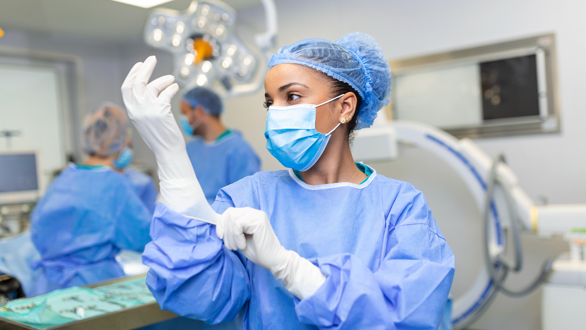 Médica coloca as luvas cirúrgicas enquanto se prepara para a cirurgia
