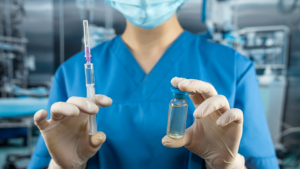 Médica anestesiologista segura e exibe uma injeção e ampola descartáveis